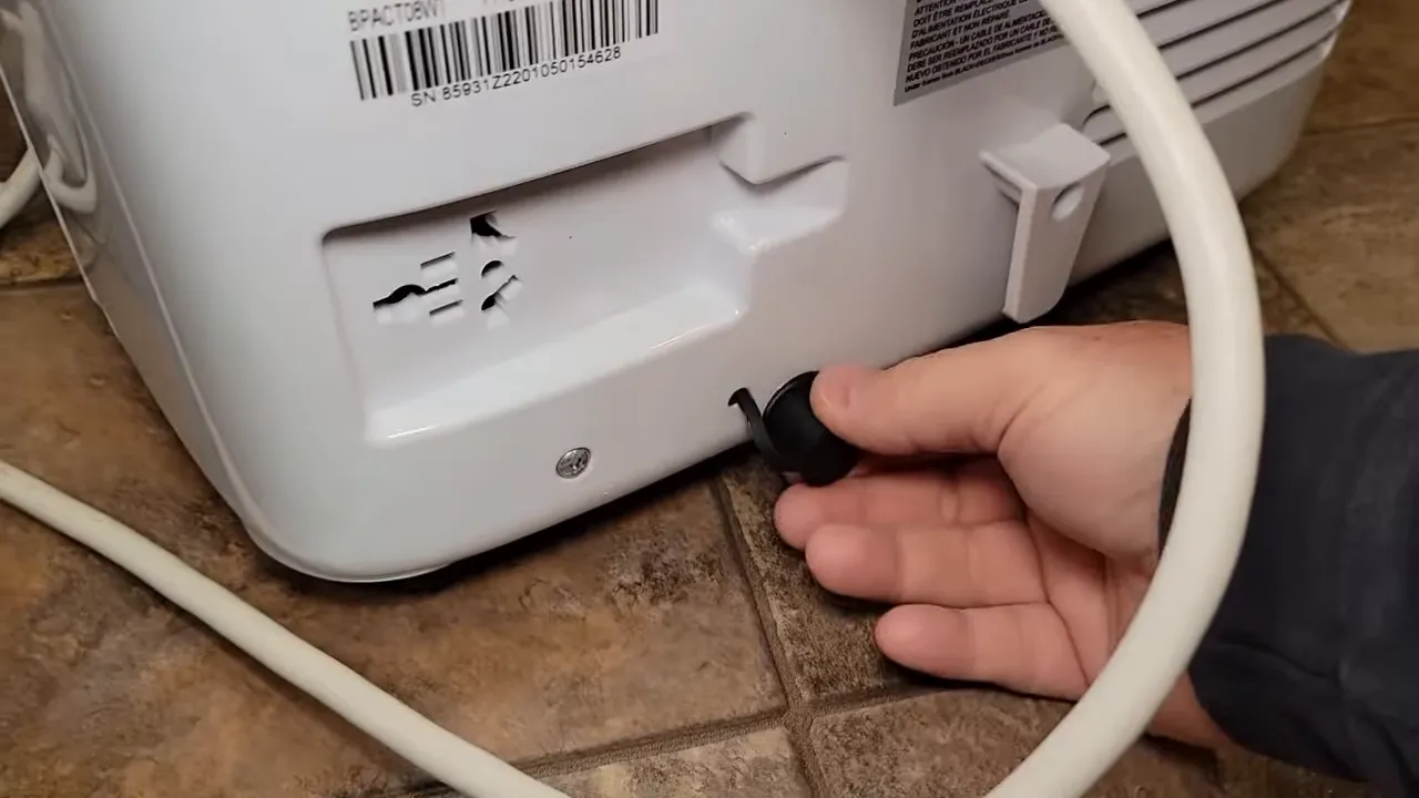 Putting the drain plug into the back of the unit