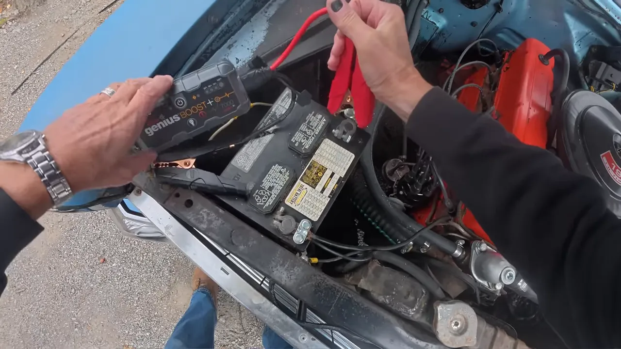 NOCO Boost GB40 jump starter unit sitting beside a car battery