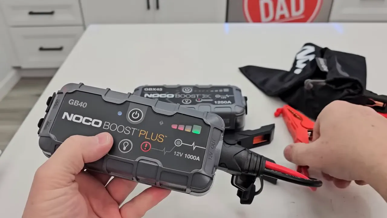 Plugging the clamp module into the jump starter and attaching clamps to battery