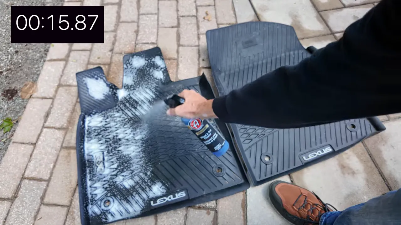 Spraying cleaner over a rubber floor mat
