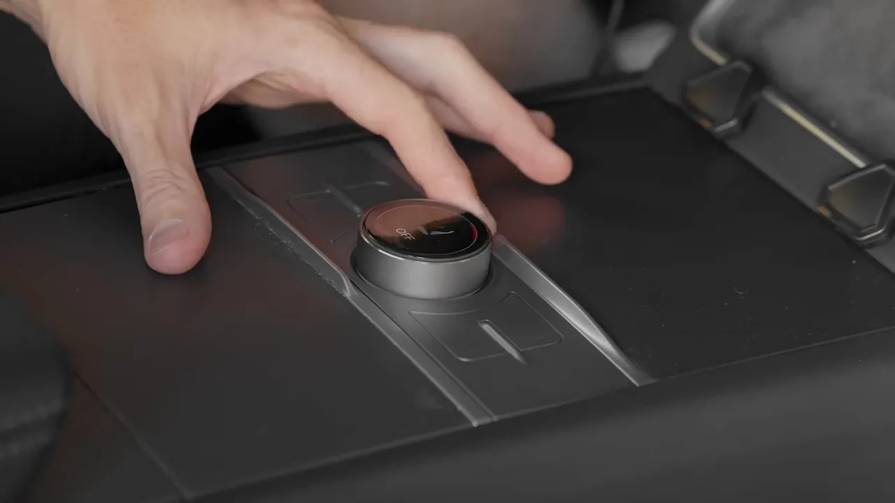 Hand using illuminated round S3XY Knob installed in a Tesla center console
