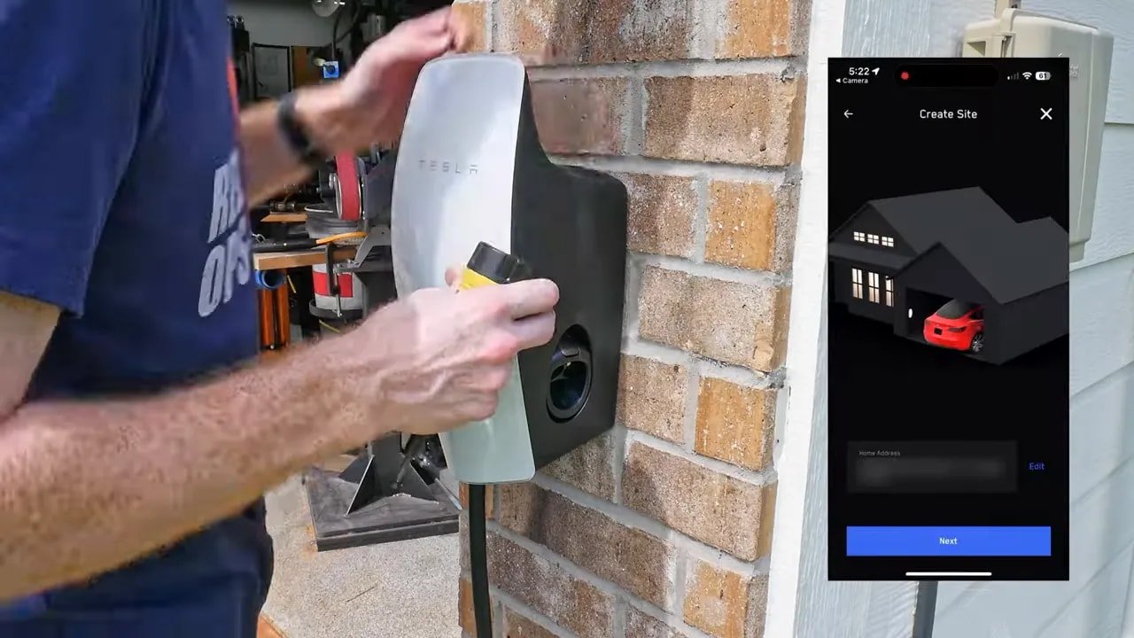 Tesla Wall Connector mounted on brick with a phone setup screen shown beside it