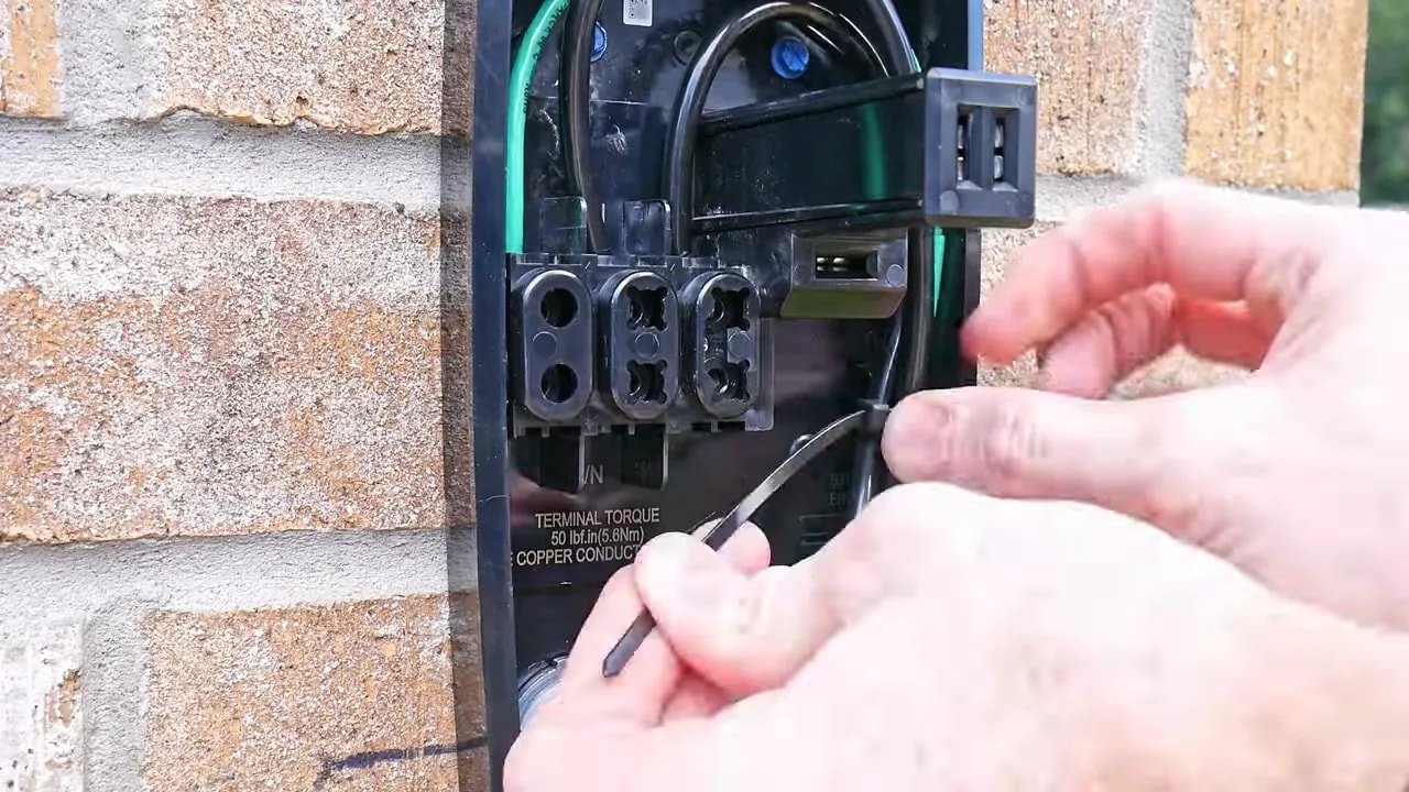Tesla Universal Wall Connector interior with black hot conductors and green grounding conductor connected to terminals
